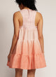 Back view of a woman standing in a dip-dyed green sleeveless dress with hand embroidered detail on the yoke