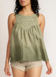 Close up of a woman wearing a dip-dyed sleeveless top with pom-pom trim and hand embroidered detail with beige shorts