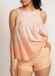 Close up of a woman wearing apricot shorts with pink piping detail and a pink top