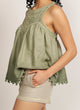 Close up of a woman wearing beige shorts with yellow piping detail yellow lined pockets and a green top