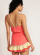 Back view of woman in Watermelon pink skirt  with pom-pom trim and yellow and pink ruffle detail and matching tank top