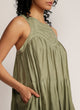 Close up of a woman in a dip-dyed green sleeveless dress with hand embroidered detail on the yoke